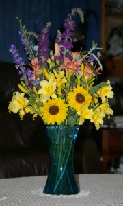 bouquet with sunflowers, purple larkspur, peach and yellow day lilies, and sage blooms