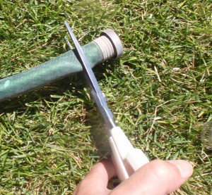 using Cutco scissors to remove the broken hardware on the hose