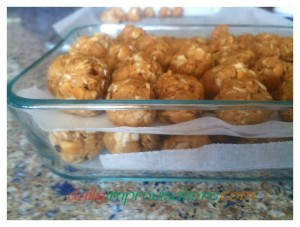 Peanut butter snack balls layered with wax paper to keep them from sticking together while in the refrigerator.