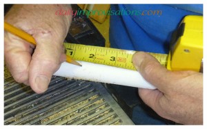 Marking how far from the ends of the PVC pipe handle to drill the holes.
