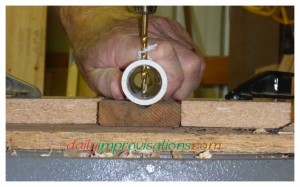 Drilling a hole through PVC pipe with a drill press.